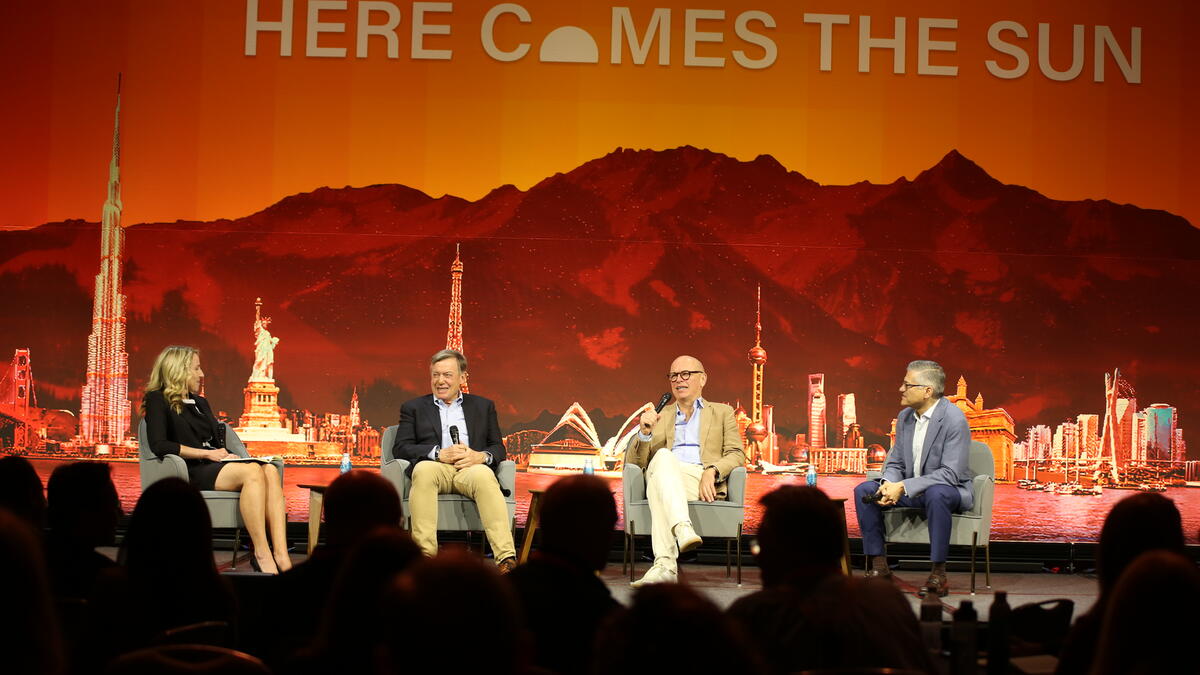 Four people sit smiling on stage as they discuss how innovation and technology can make education more globally accessible.