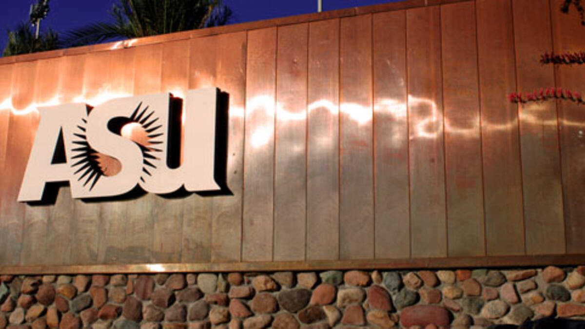 A large copper and stone sign that features the ASU sunburst logo.