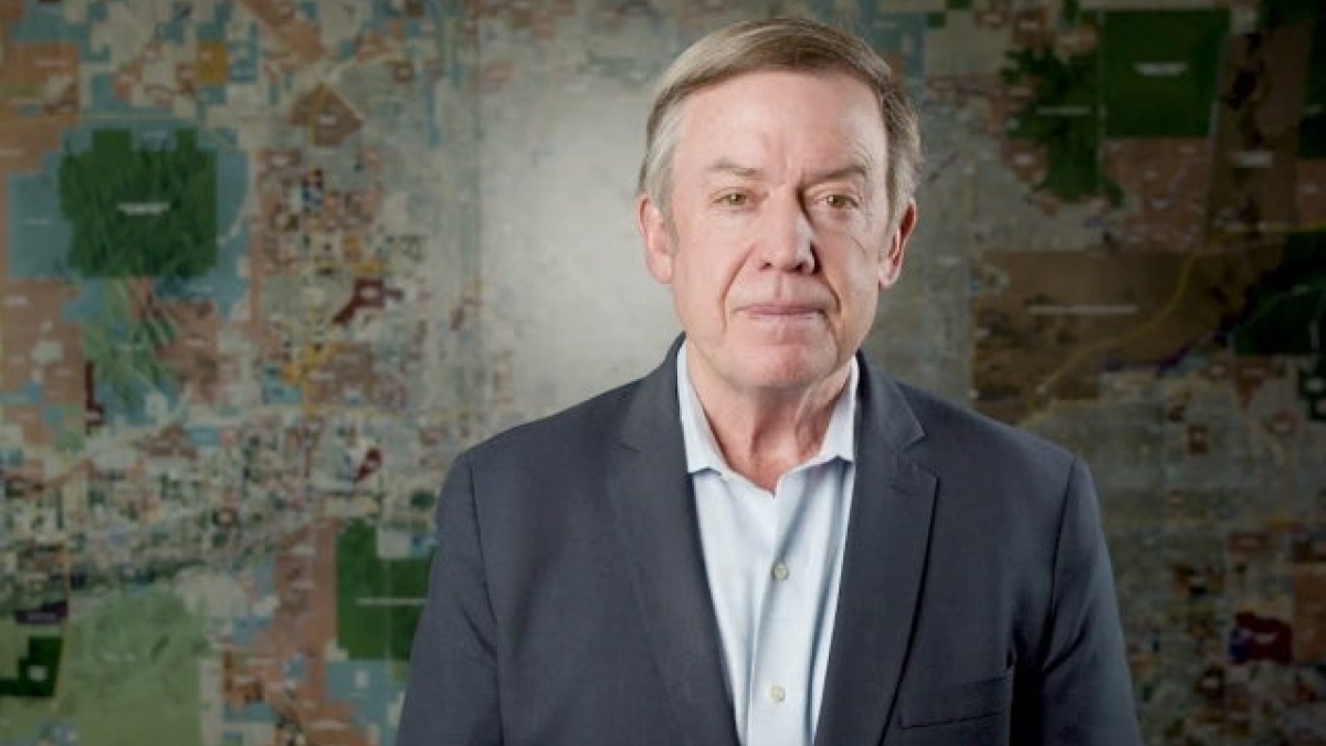 Michael Crow stands in front of a valley map in the Fulton Center.