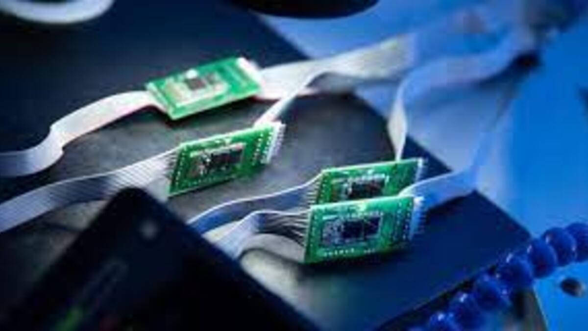 Four green computer microchip panels lie side-by-side on one edge against a black backdrop in a computer.